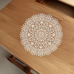 Decorative white mandala design on a wooden surface