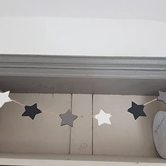 Star-shaped decorative banner on a wooden shelf with a white wall background