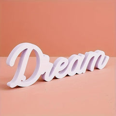 White decorative word 'Dream' on a peach background