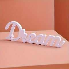 White decorative word 'Dream' on a peach-colored background