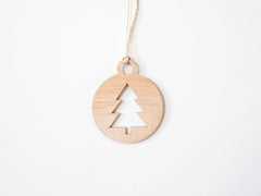 Wooden pendant with a tree cutout on a white background