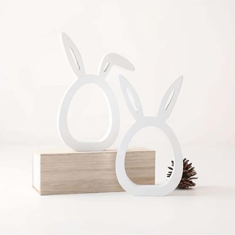 White rabbit-shaped lamps on a wooden block with a pine cone on a white background