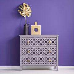 Gray dresser with geometric pattern against a purple wall
