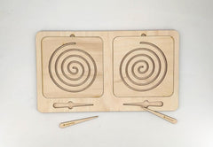 Wooden puzzle with spiral designs and wooden tools on a white background