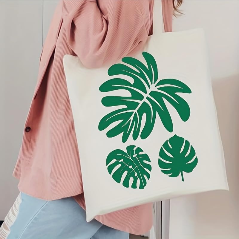 Person holding a tote bag with green leaf patterns