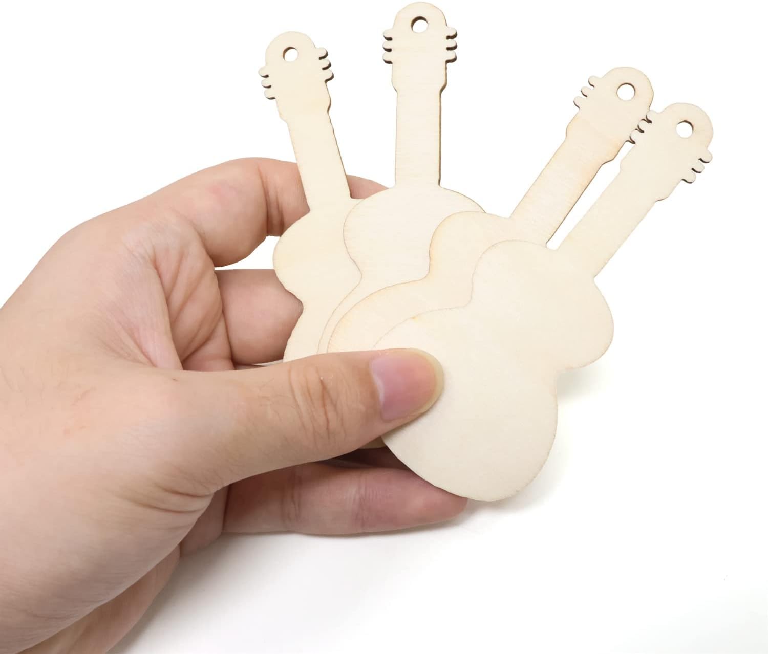 Hand holding a set of wooden guitar-shaped tools on a white background
