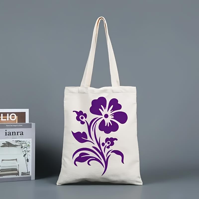 White tote bag with purple floral design next to a magazine on a gray background