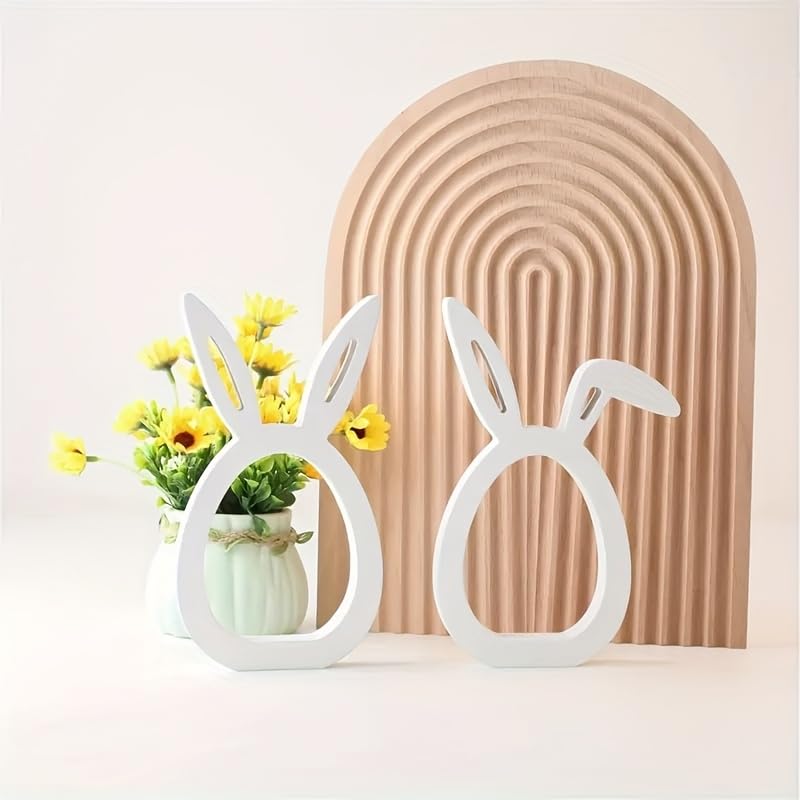 Decorative bunny-shaped vases with plants against a beige arch-shaped wall.