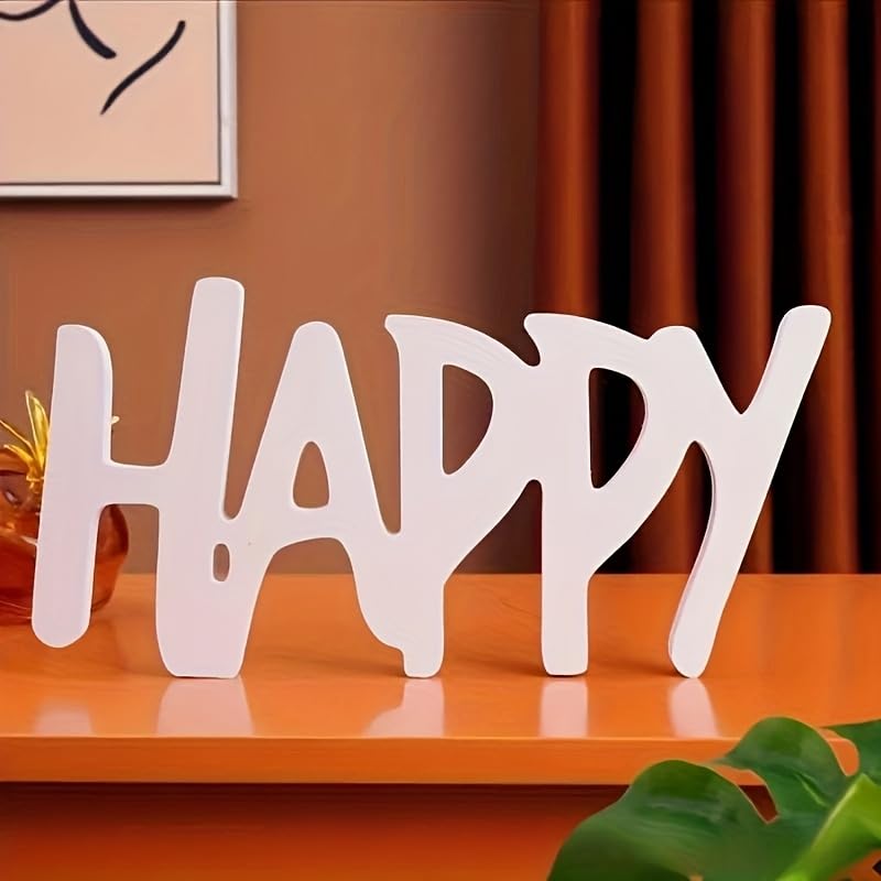 White decorative word 'HAPPY' on a wooden surface with a blurred background