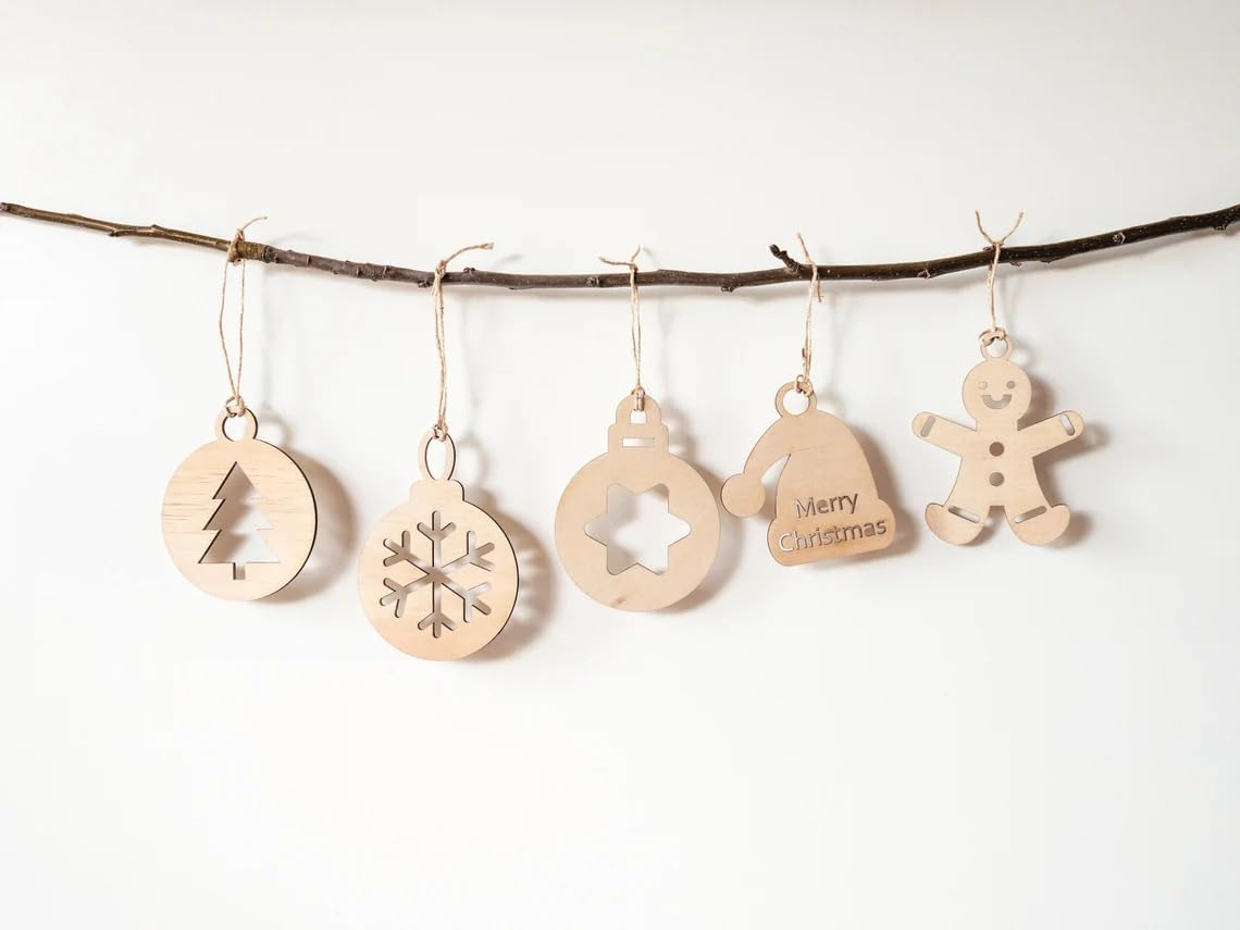 Wooden Christmas ornaments on a branch against a white background