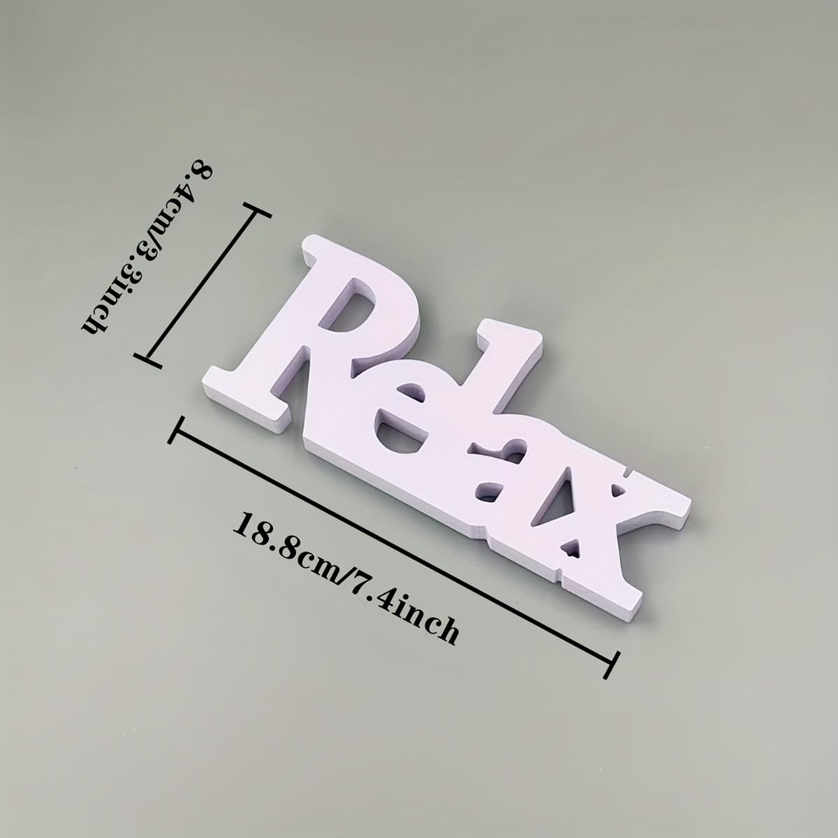 White 'Relax' sign with measurements on a gray background