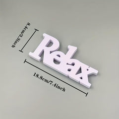 White 'Relax' sign with measurements on a gray background