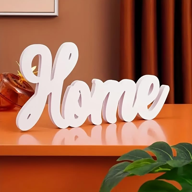 White decorative word 'Home' on a reflective surface with a warm-toned background