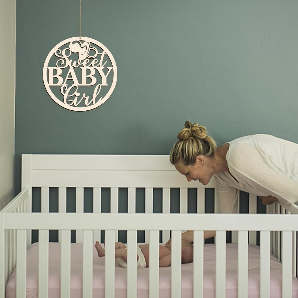 Woman leaning over a crib with a 'Sweet Baby Girl' sign on the wall.