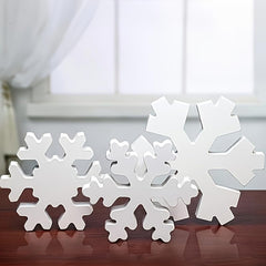 White snowflake decorations on a wooden surface with a blurred background