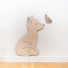 Wooden wall decoration of a fox and a butterfly on a white wall.