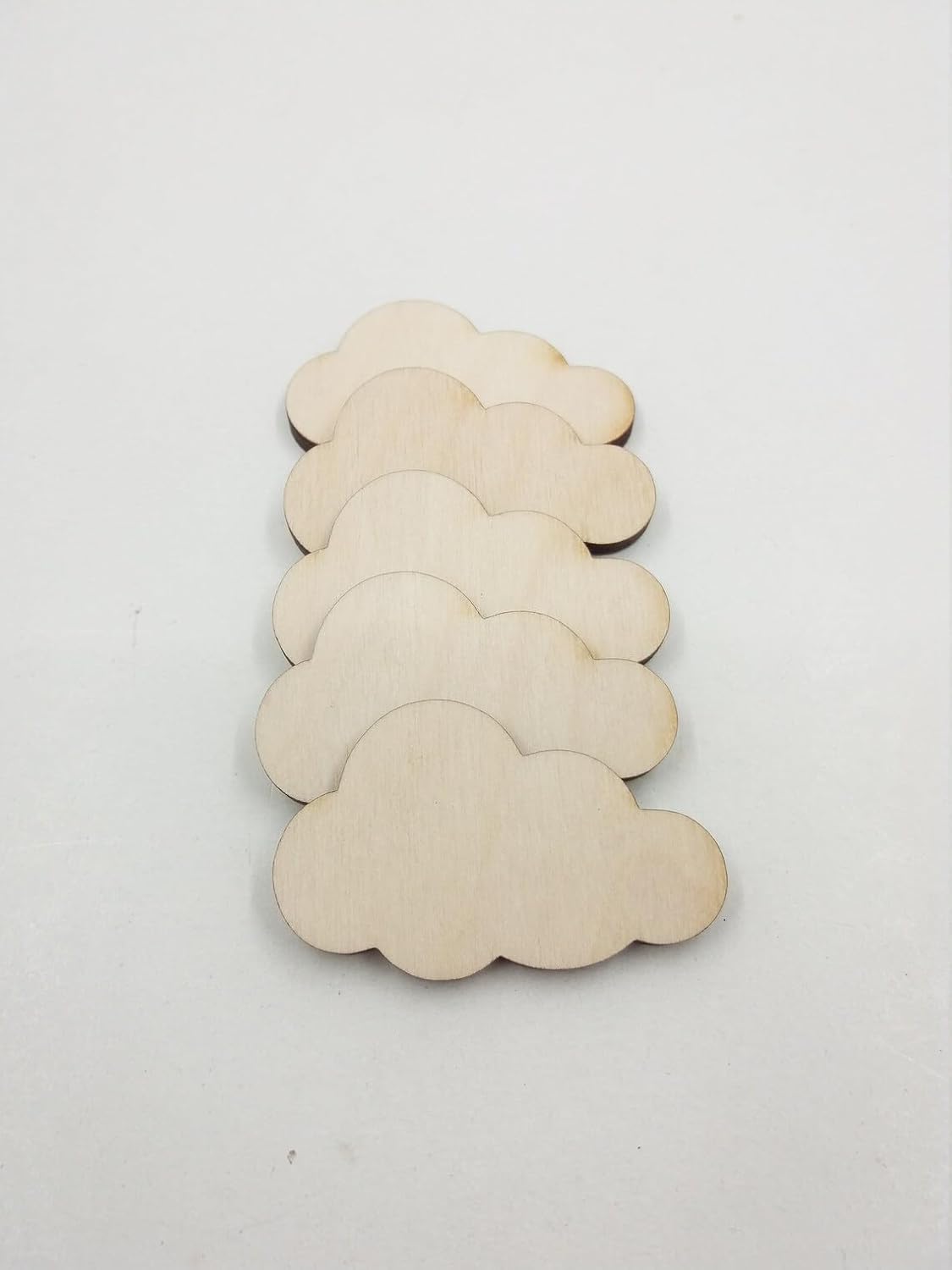 Set of cloud-shaped wooden cutouts on a white background