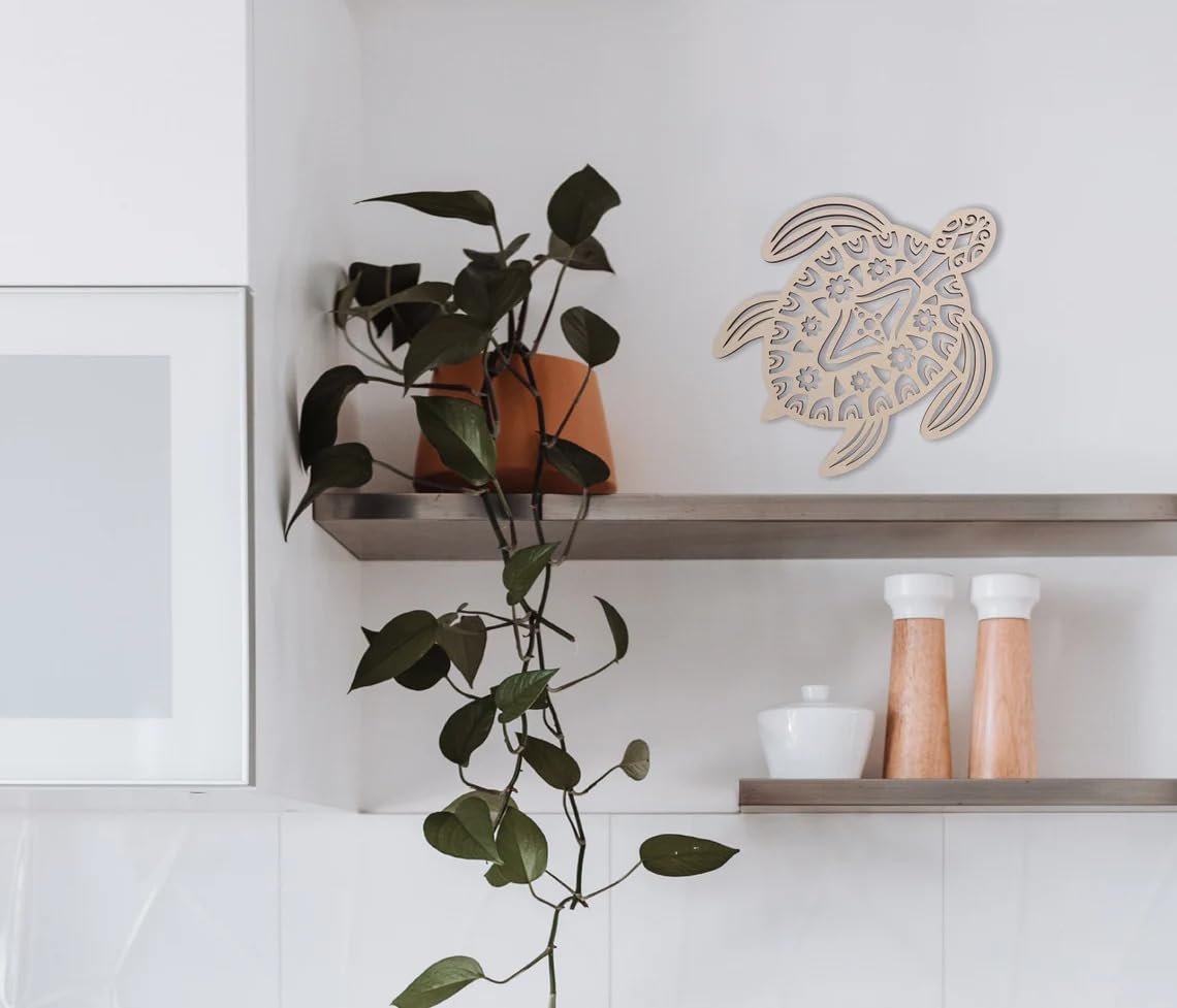 Decorative turtle wall art on a shelf with a plant and kitchen items in the background.