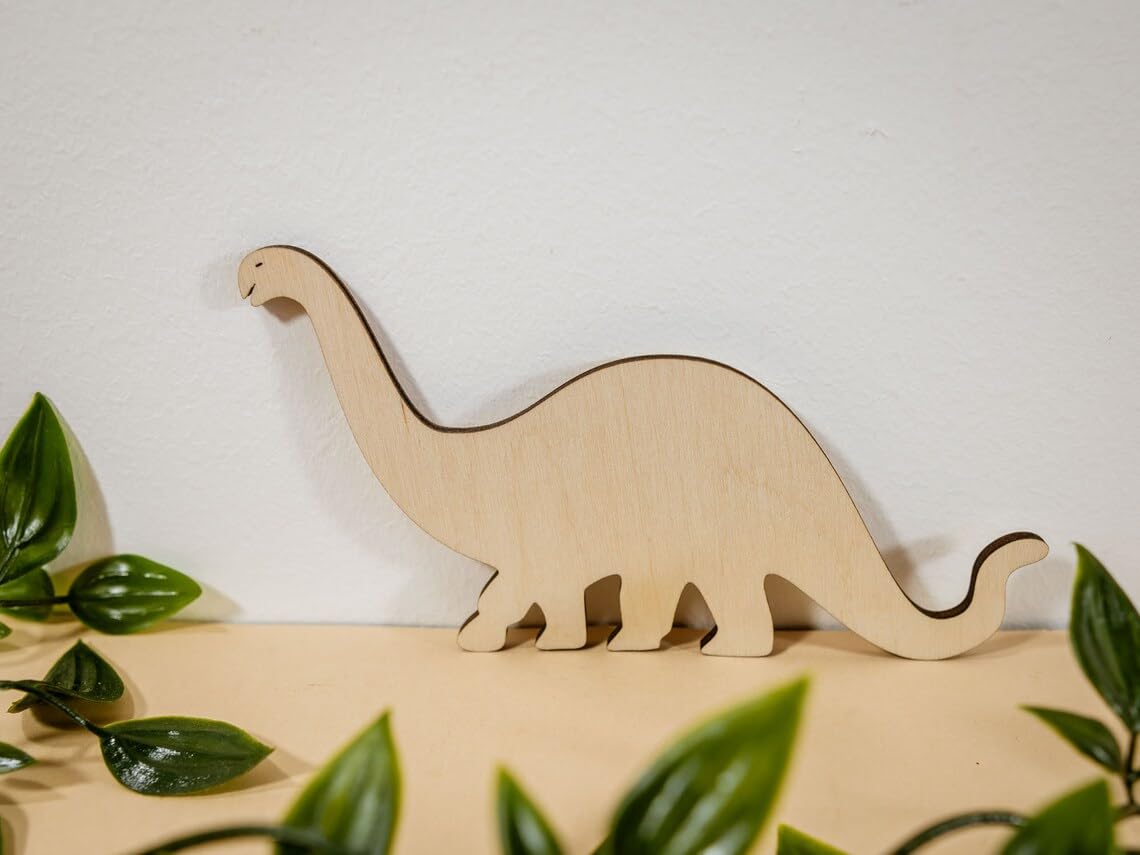 Wooden dinosaur model on a white background with green leaves
