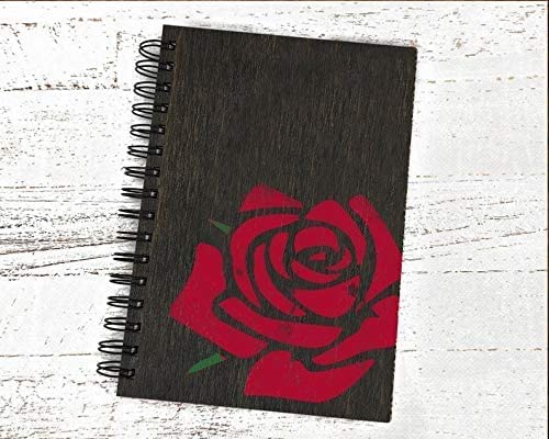 Notebook with a red rose design on a white wooden surface