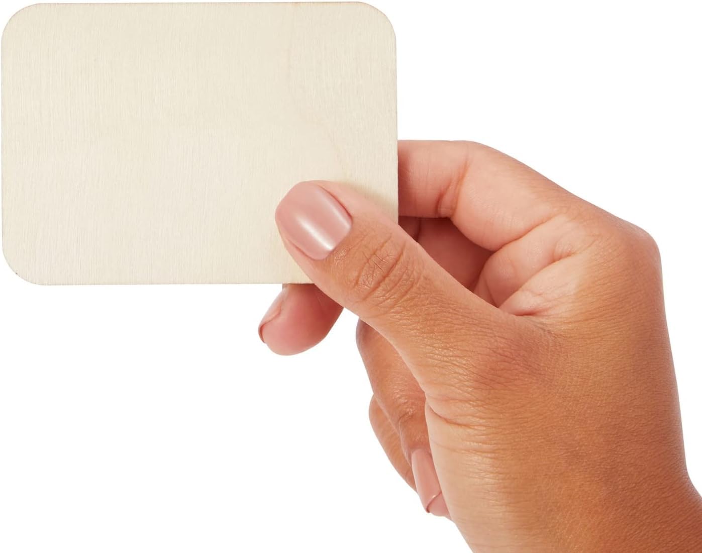 Hand holding a beige square swatch against a white background