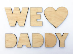 Wooden letters spelling 'WE LOVE DADDY' on a white background