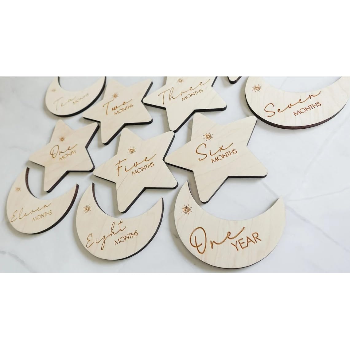 Wooden moon and star-shaped milestones with milestone numbers on a white background