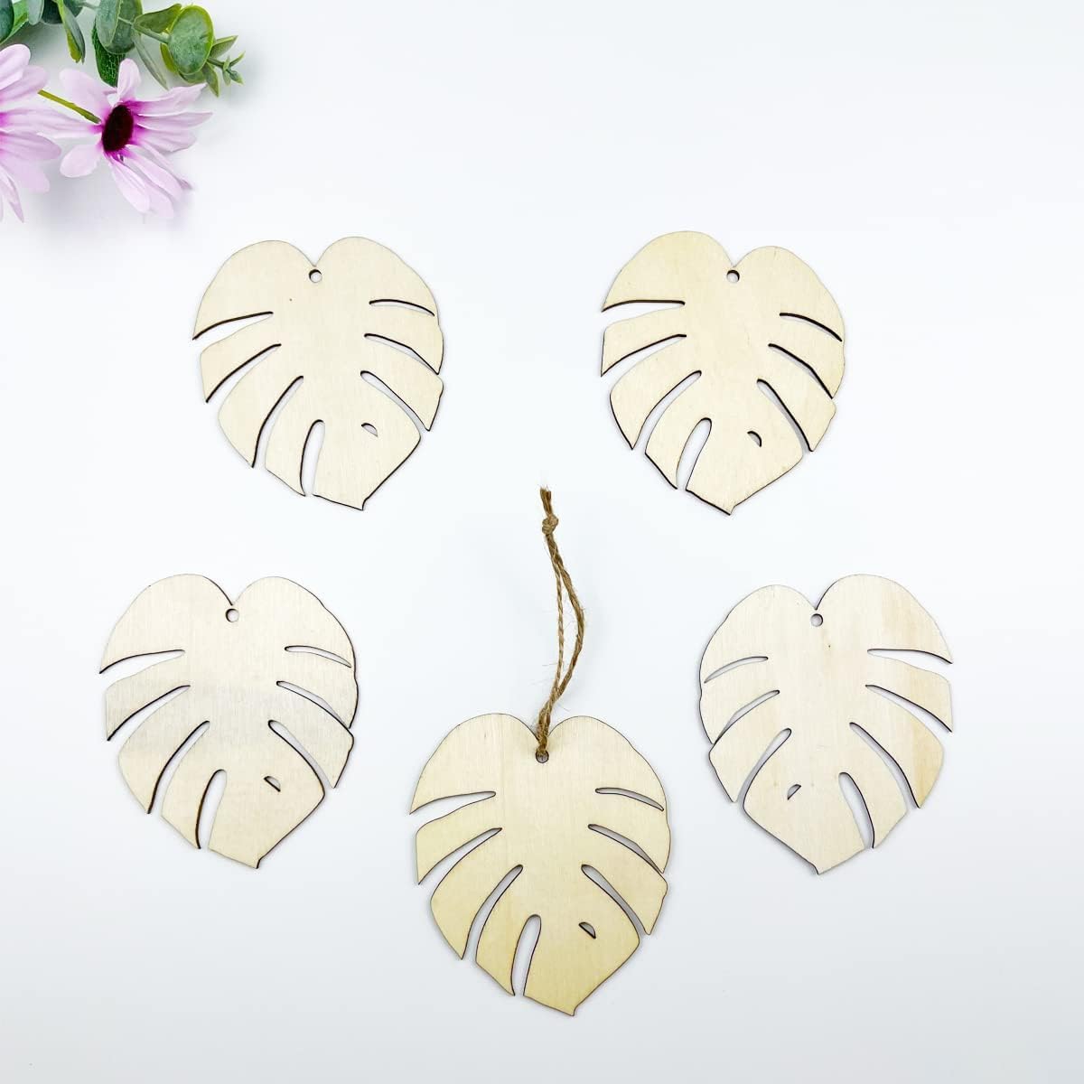 Set of wooden monstera leaf decorations on a white background