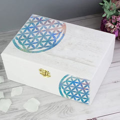 White wooden box with colorful flower-of-life design on a wooden surface.