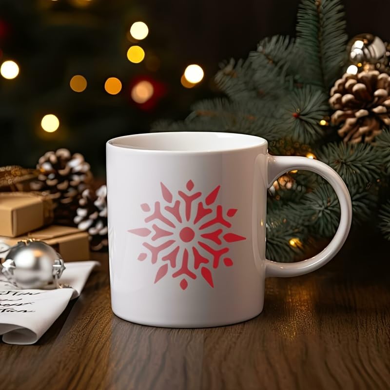 White mug with red snowflake design on a wooden table with Christmas decorations.