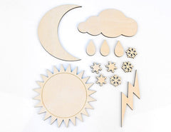 Set of wooden weather-themed shapes including sun, moon, cloud, raindrops, snowflakes, and lightning bolt on a white background.