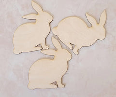 Three wooden rabbit shapes on a light background
