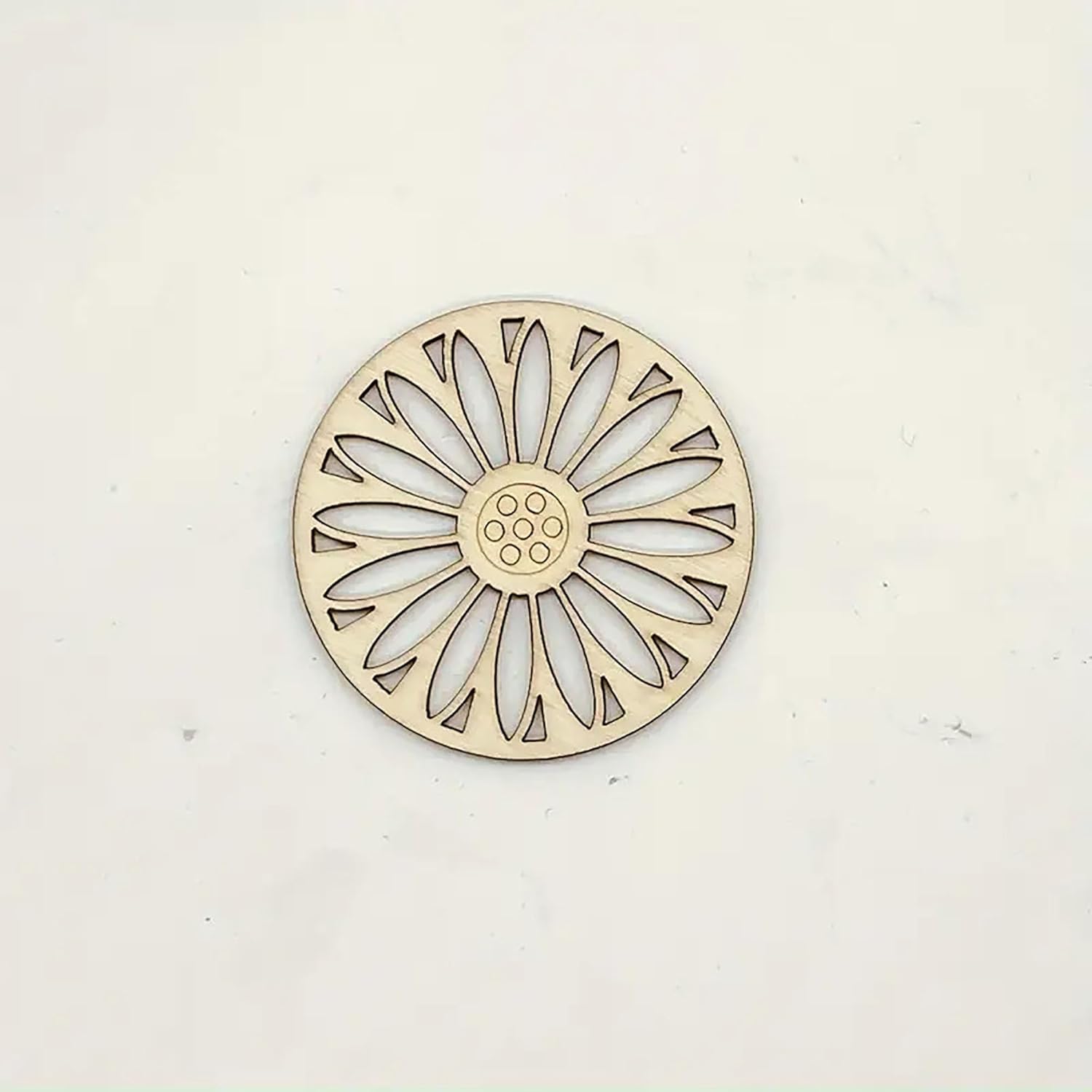 Decorative metal trivet with sunflower design on a white background