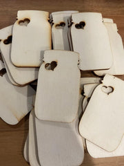 Stack of beige phone cases with heart cutouts on a wooden surface