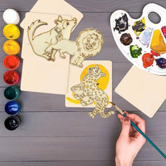 Hand painting a lion design on a wooden board with paint supplies nearby.