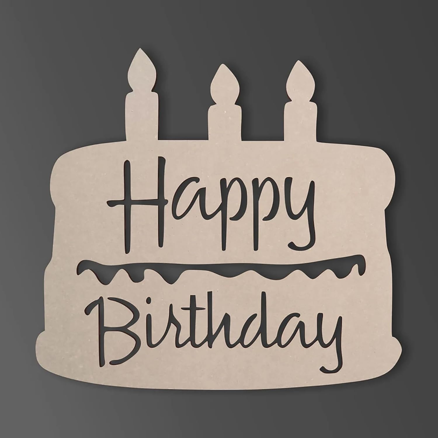 Cardboard cutout of a birthday cake with 'Happy Birthday' text on a dark background