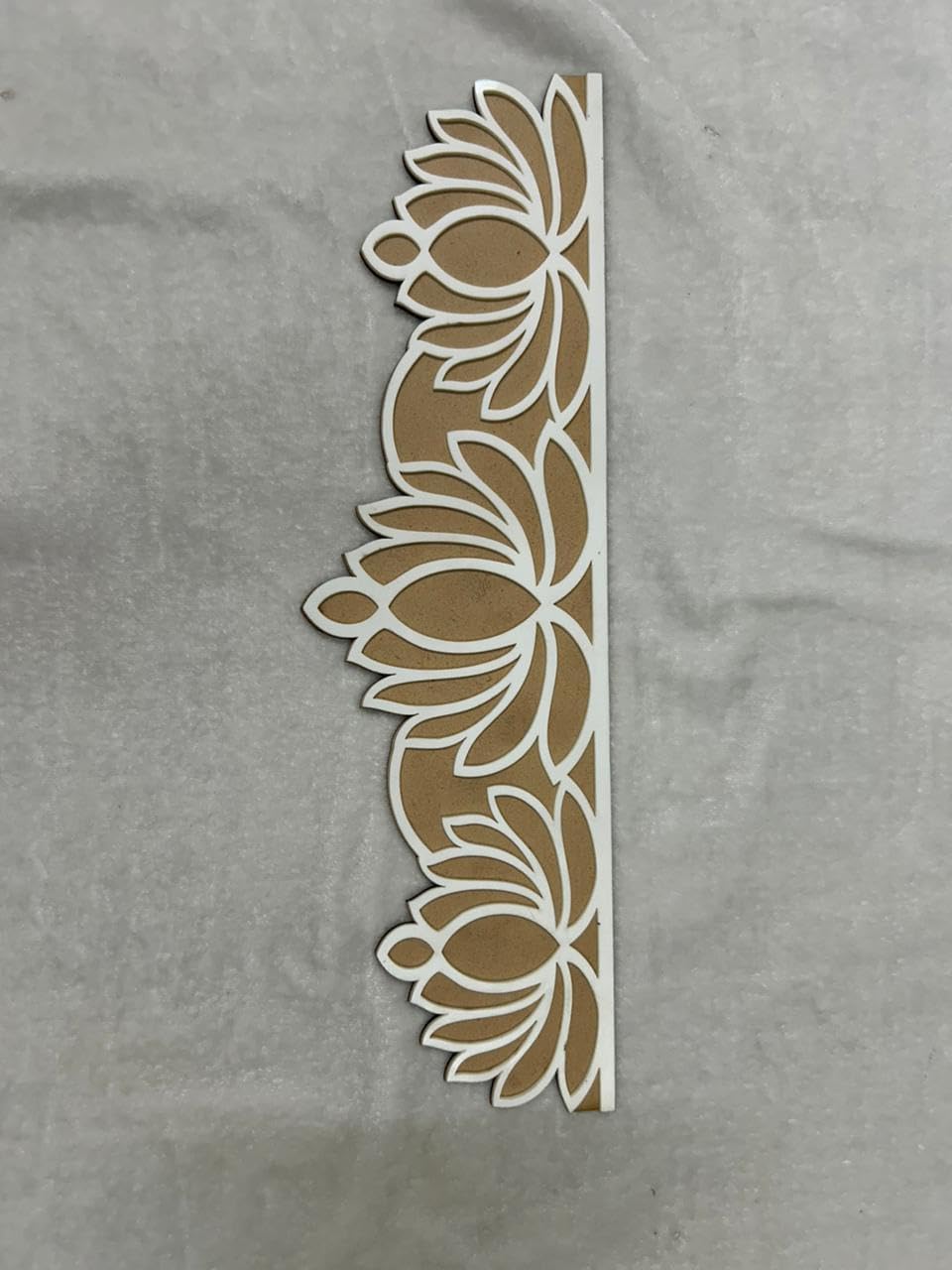 Decorative floral cutout on a gray fabric background