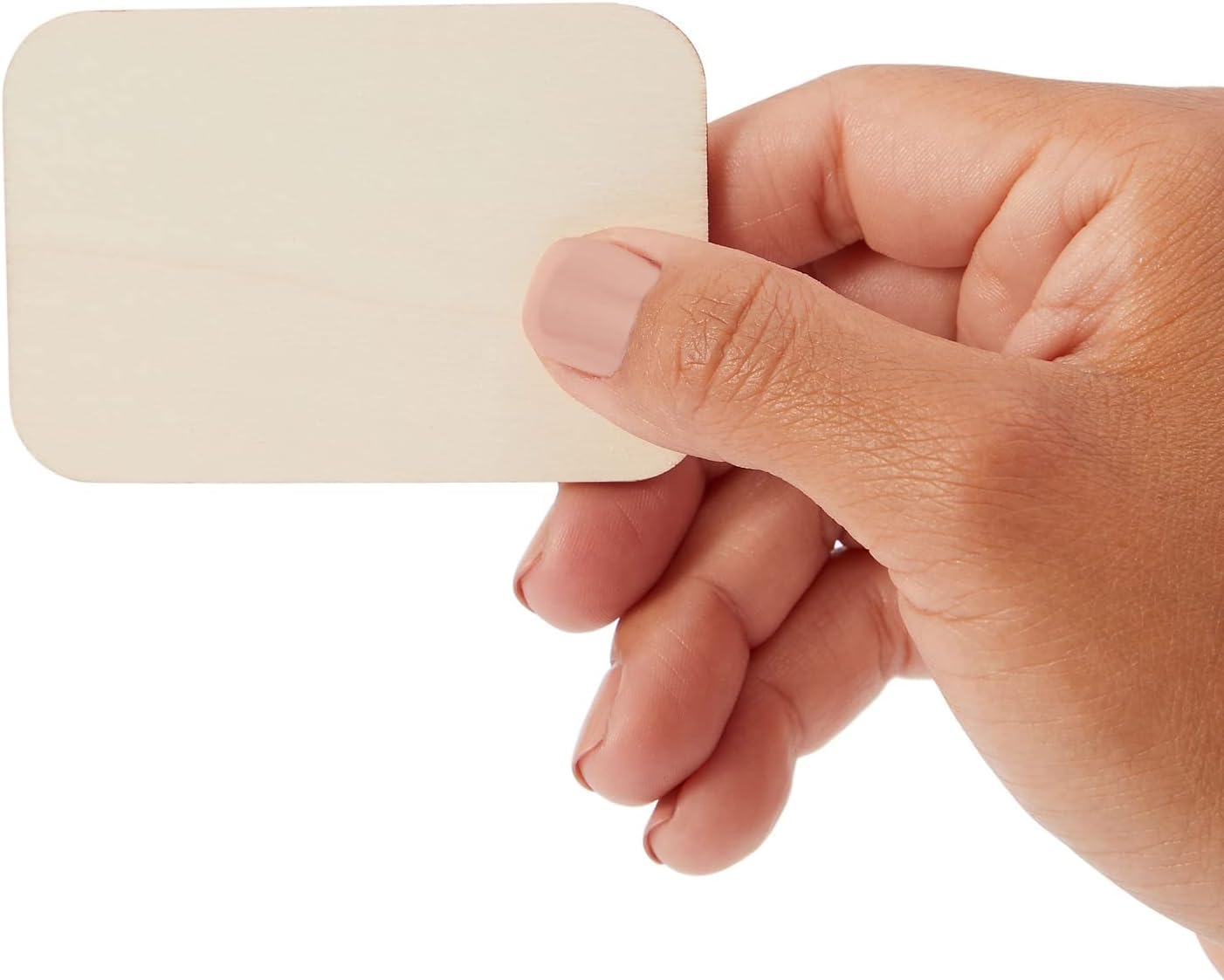 Hand holding a beige square object against a white background