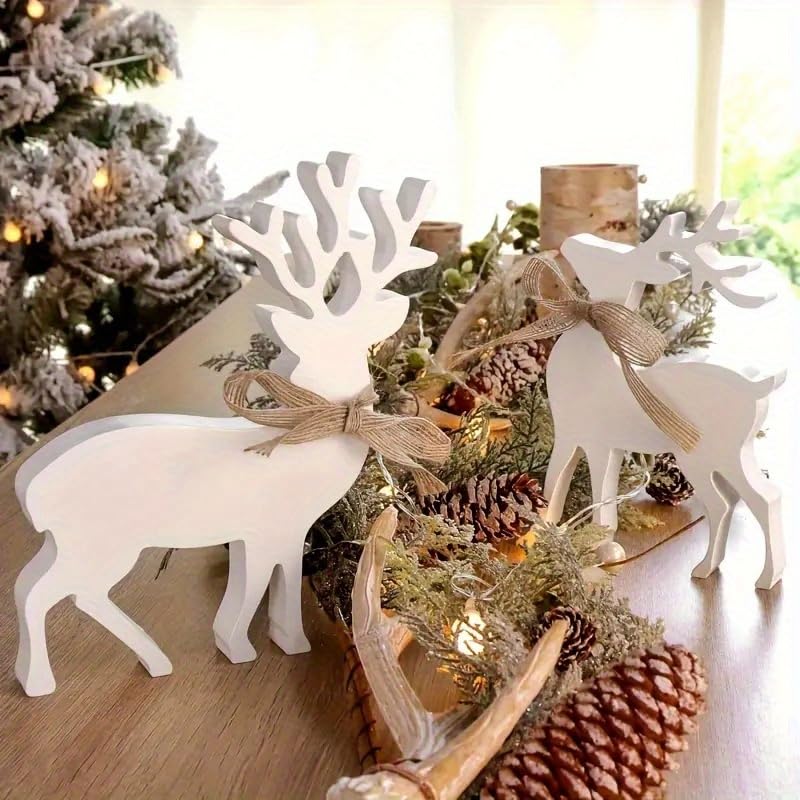 White deer figurines with burlap ribbons on a Christmas-themed table setting with pinecones and greenery.