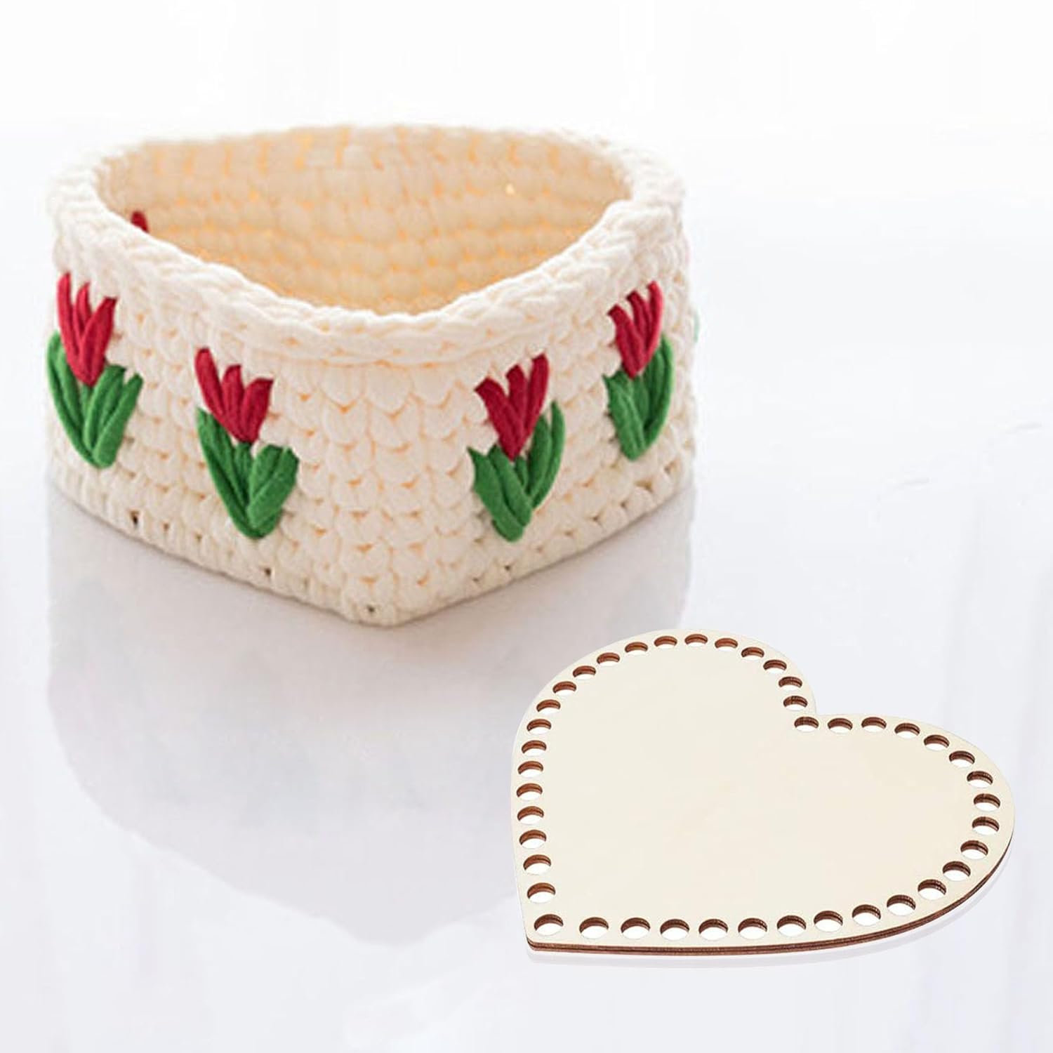 Crocheted egg holder with floral design and matching heart-shaped coaster on a white background