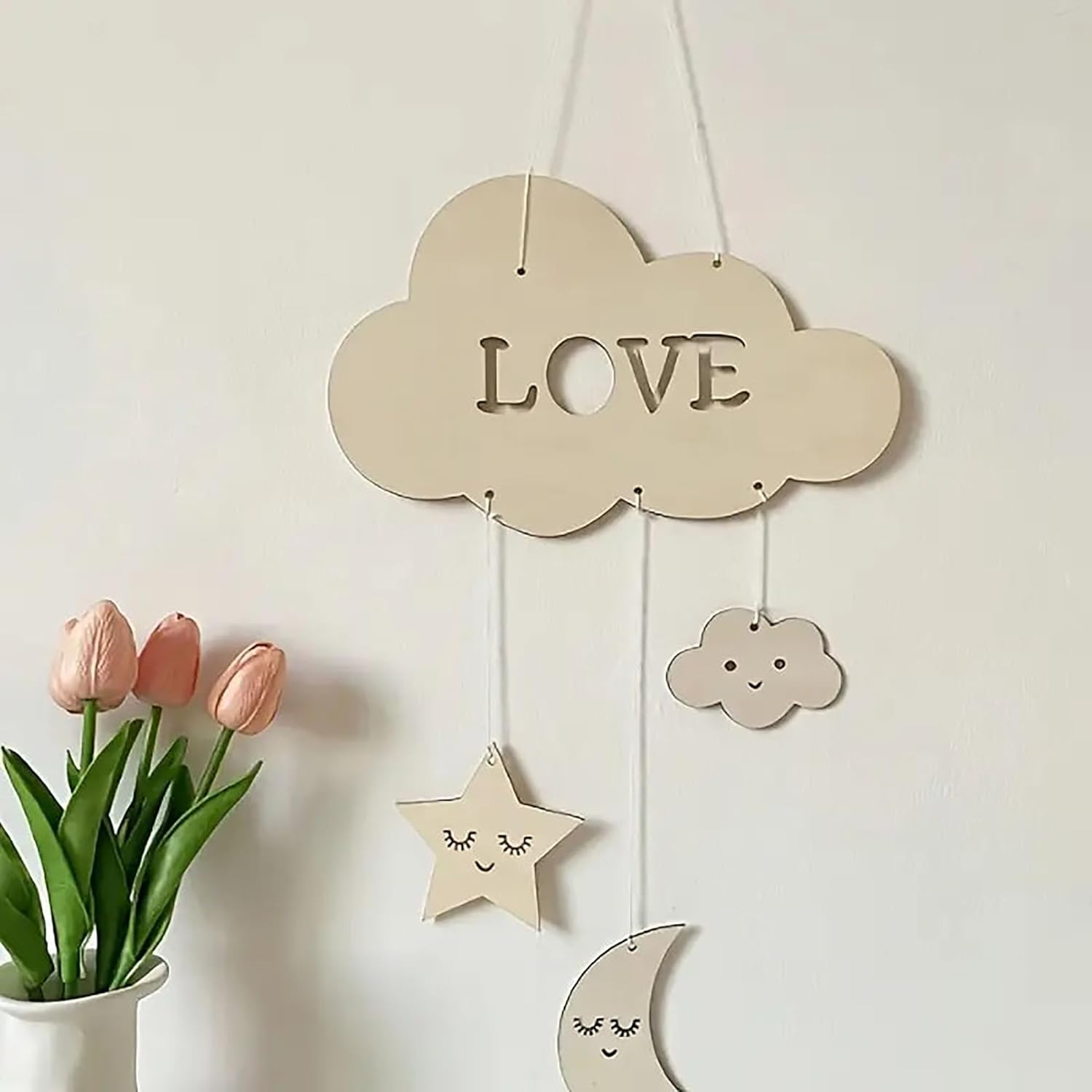 Decorative cloud-shaped sign with 'LOVE' on a light background with flowers.