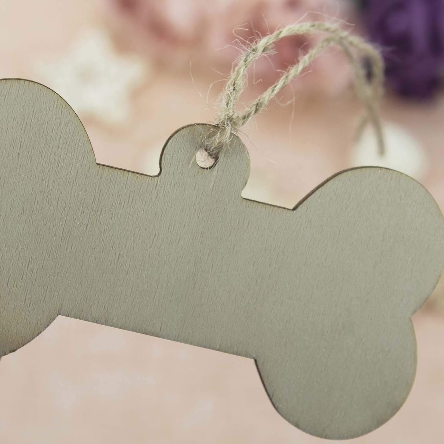 Green bone-shaped tag with string on a blurred background