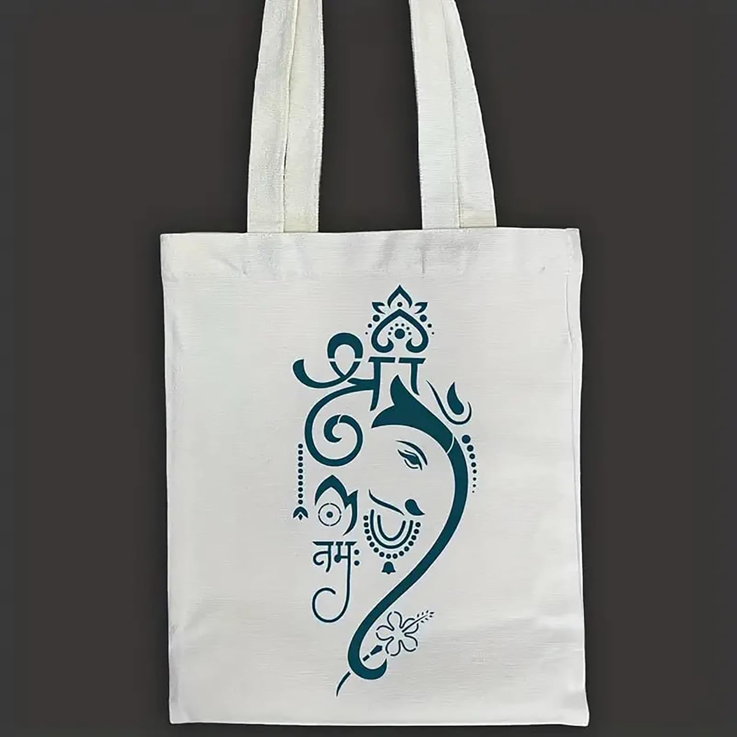 White tote bag with a blue decorative design on a dark background