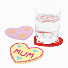 Heart-shaped coasters with floral design and 'MUM' text on a glass of water.