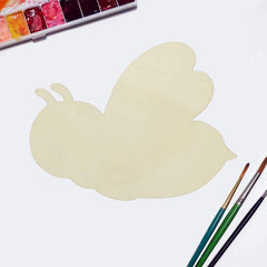 Butterfly-shaped watercolor paper with watercolor paints and brushes on a white background