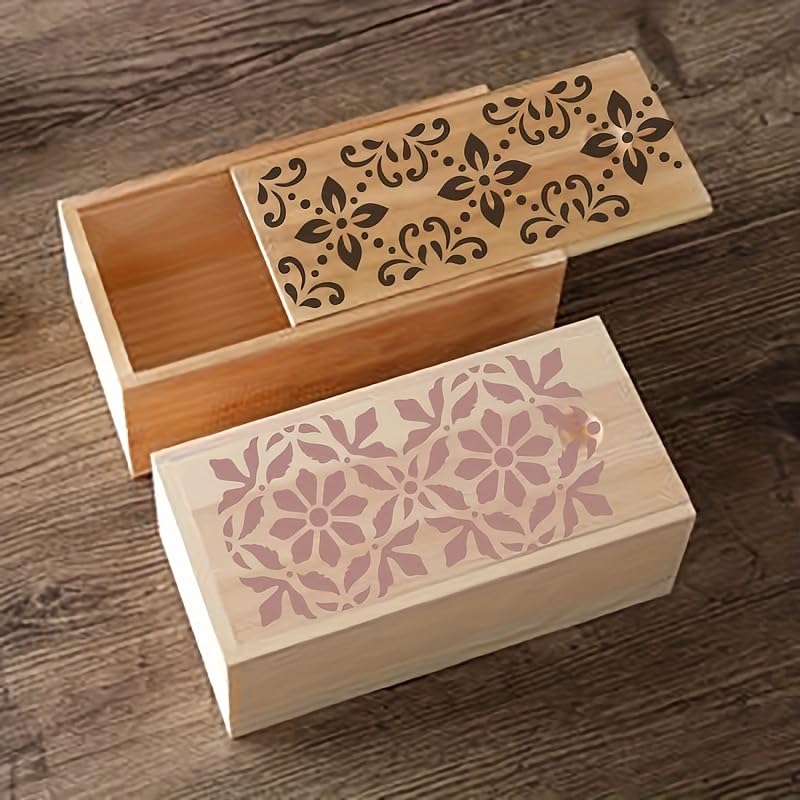 Two wooden boxes with floral patterns on a wooden surface