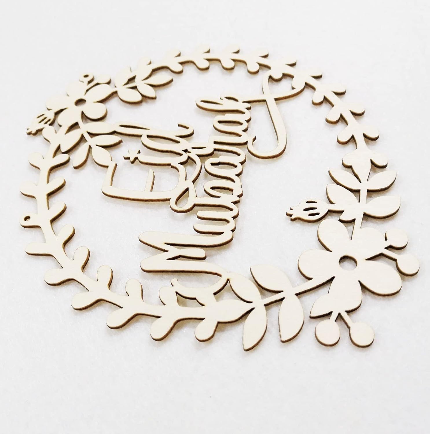 Wooden wreath cutout with floral and deer design on a white background