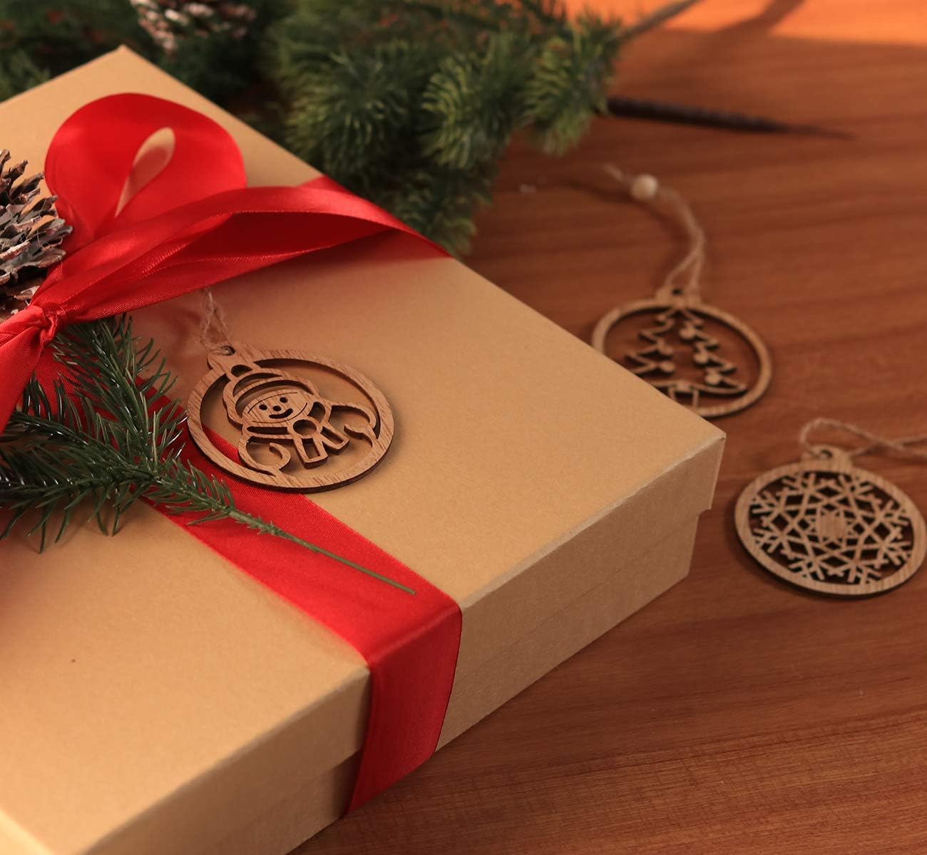 Gift box with red ribbon and Christmas decorations on a wooden surface