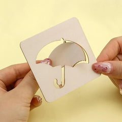 Gold earring holder with a gold earring on a beige card against a yellow background