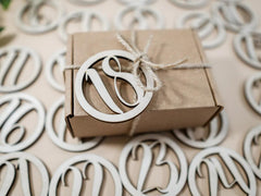 Brown gift box with a wooden number '18' ornament on a decorative background.